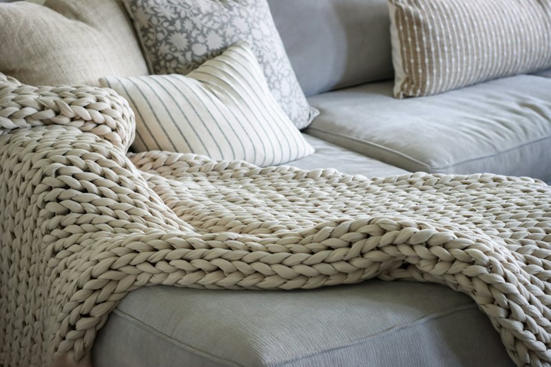 Plaid en grosse maille sur un canapé